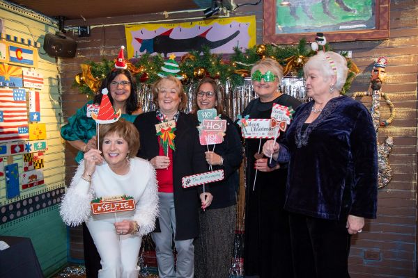 Group of women celebrating Christmas with festive props and decorations.