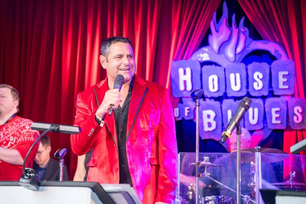 Man in red jacket singing on stage at House of Blues.