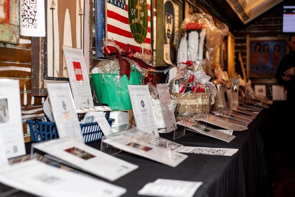 Silent auction table with gift baskets and bid sheets.