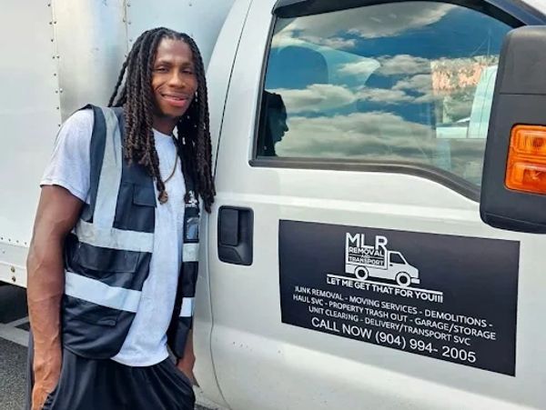 Man standing next to a removal service truck.
