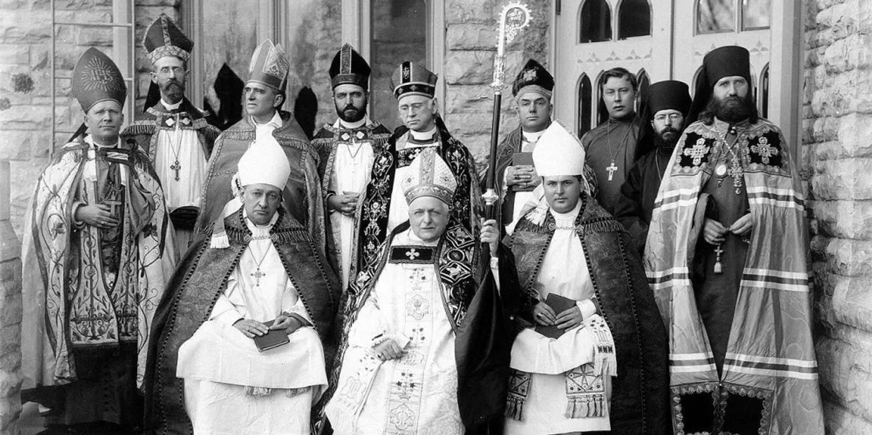 A group of clergymen in ceremonial robes posing for a formal photo.