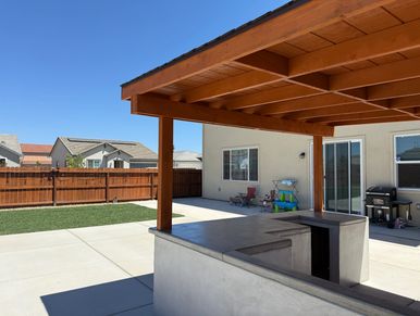 Backyard patio with pergola and outdoor kitchen.