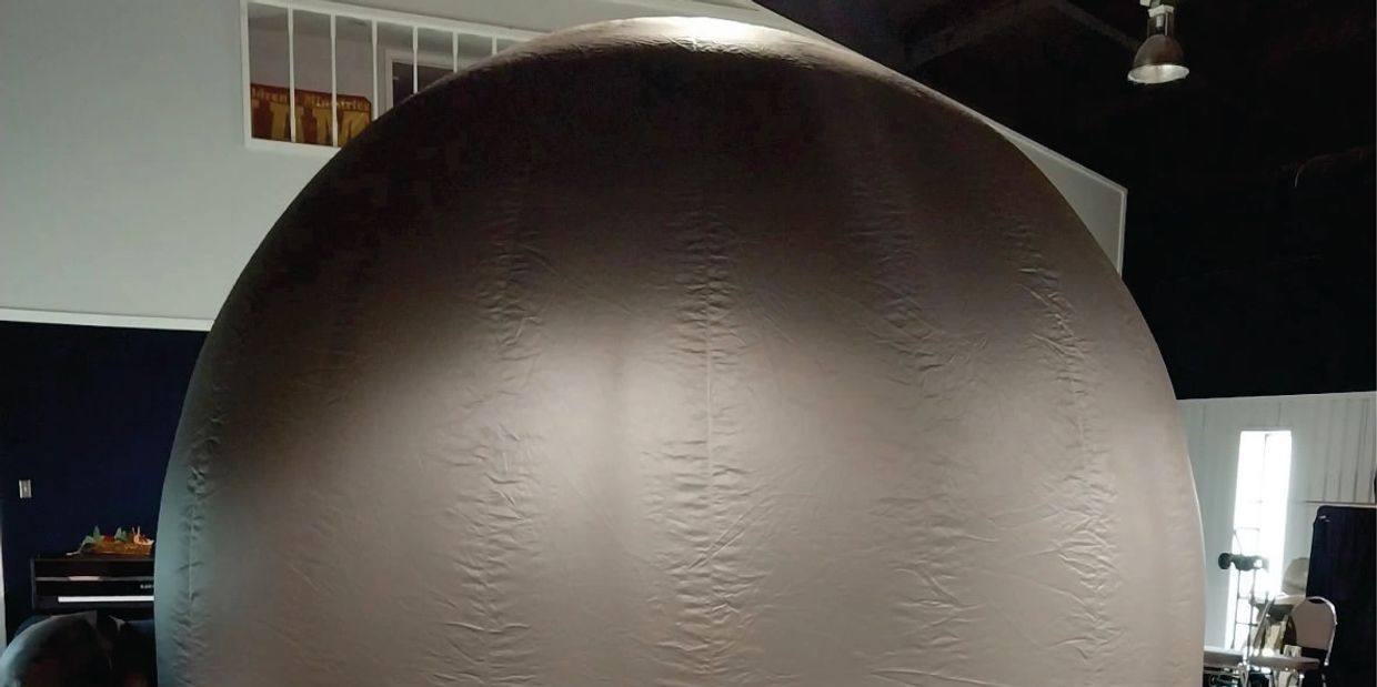 A large, dome-shaped inflatable structure indoors.