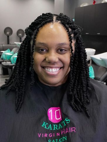 Smiling woman with fresh twisted hairstyle at a hair salon.