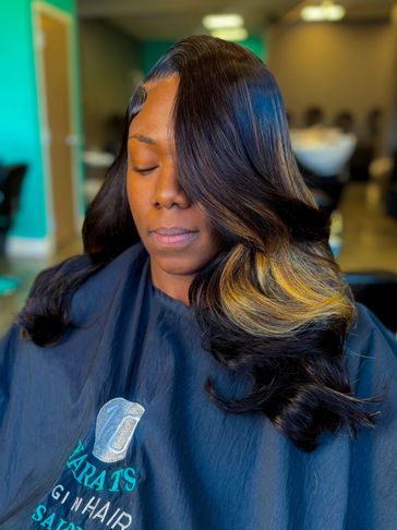 Woman with sleek, styled hair featuring dark and golden highlights.