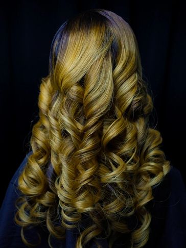 Golden blonde hair styled in tight, glossy curls.