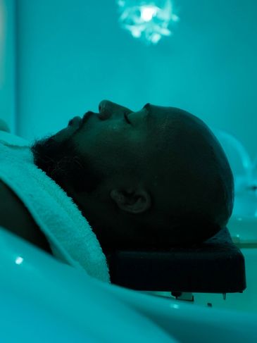 Man relaxing with eyes closed in a spa or wellness setting.