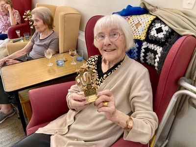 Happy woman shows off her trophy for winning a Springfield House quiz