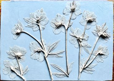 Artwork of white embossed flowers on a light blue background.