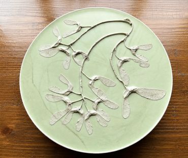Green plate with preserved branches and seeds.