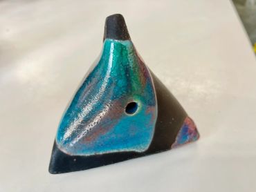 A small ceramic sculpture shaped like an animal head.