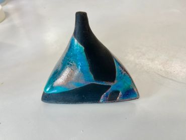 Triangular ceramic sculpture with blue and black glaze.
