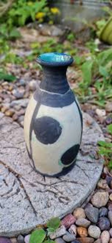 Decorative ceramic vase with black patterns.