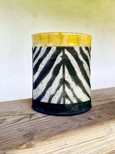 Decorative container with zebra and yellow band pattern.