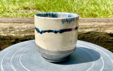 Handcrafted ceramic cup with blue glaze accents.