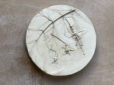 White clay plaque with botanical impressions.