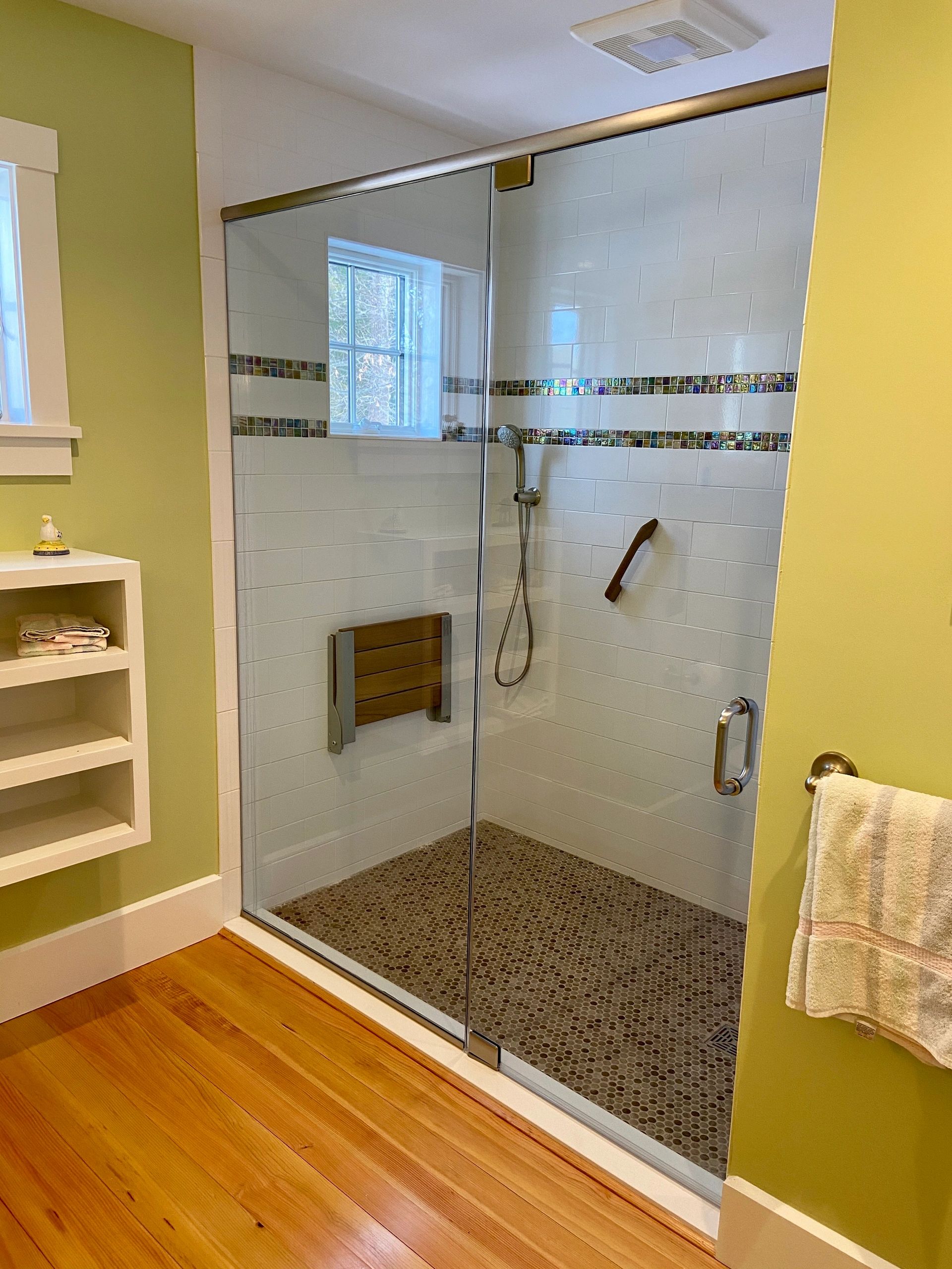 white ceramic tile shower with iridescent glass mosaic bands and floor