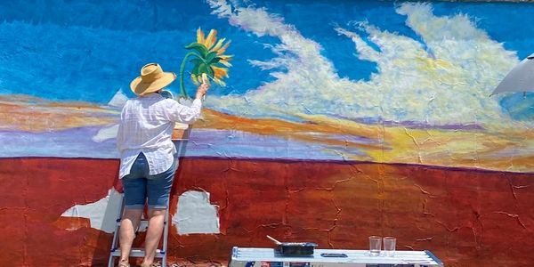 McKinney Artist Pernie Fallon paints her "Here Comes the Sun" mural for the 2022 MillHouse Wine & Wa