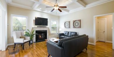 Bright living room with leather sofas, fireplace, and wall-mounted TV.