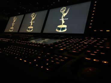 Emmy Awards displayed on screens above a keyboard.