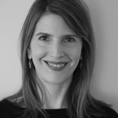 Black and white portrait of a smiling woman with shoulder-length hair.