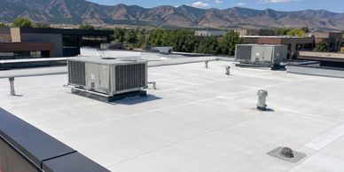 Clean commercial flat roof with rooftop HVAC units and mountain views on a Colorado business buildin