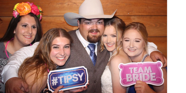 group of women with a man holding signs smiling for photo