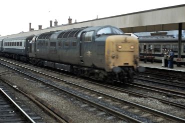 Old diesel train arriving at platform.