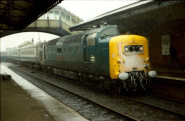 Vintage blue and yellow train at a station platform.