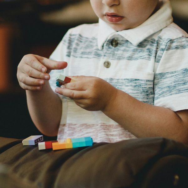 Young child playing with colorful building blocks.