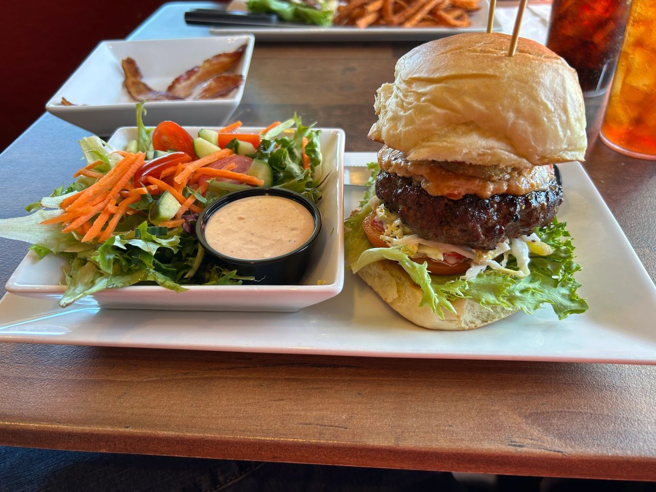 The half tank burger from GAS is a half pound burger with house made pimento cheese, slaw, applewood smoked bacon, fried pickles, lettuce, tomato and onion. 