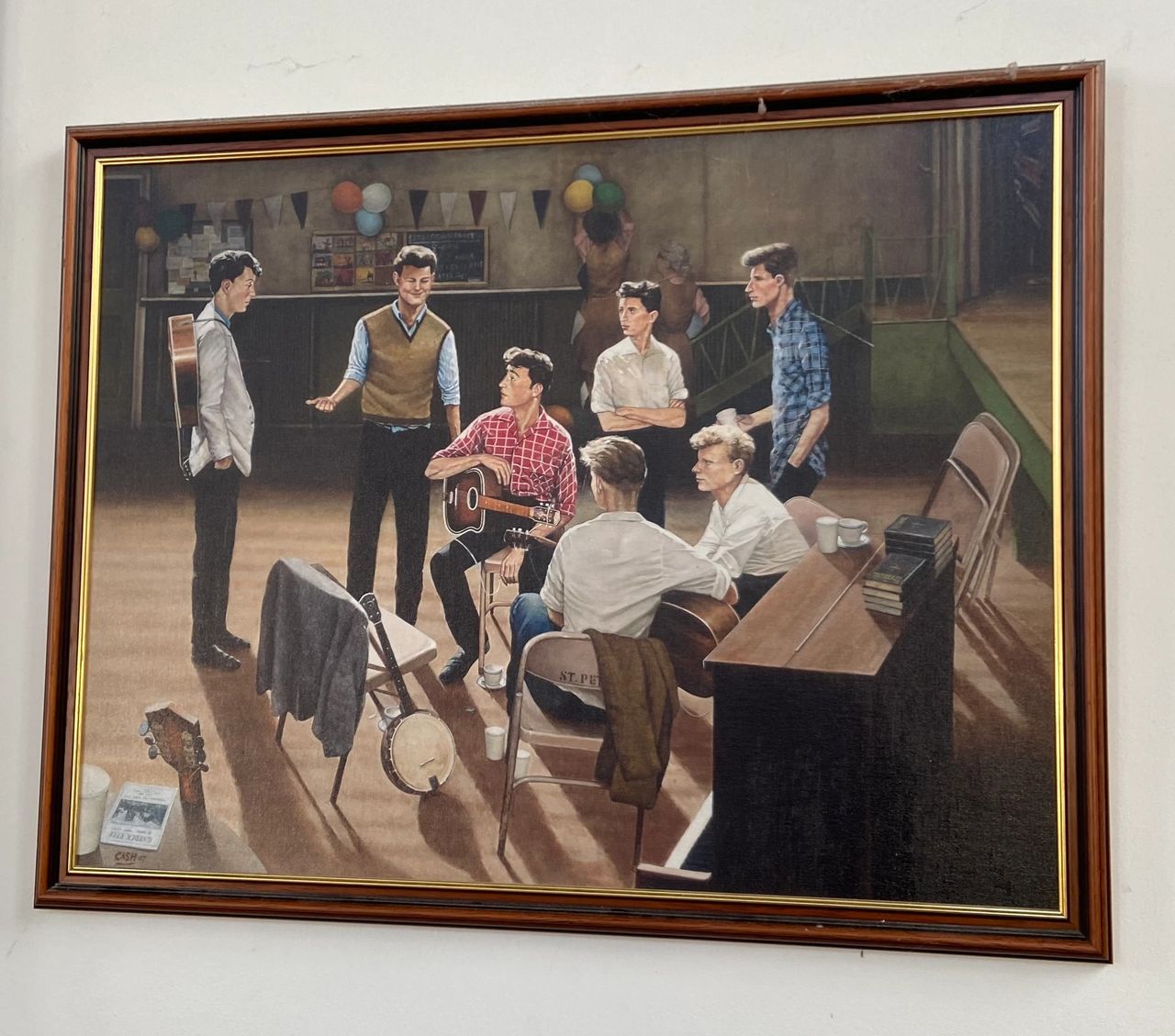One of the items on exhibit at St. Peter’s Church Hall in Liverpool is this painting depicting the day John Lennon met Paul McCartney. The painting was created by Eric Cash. 