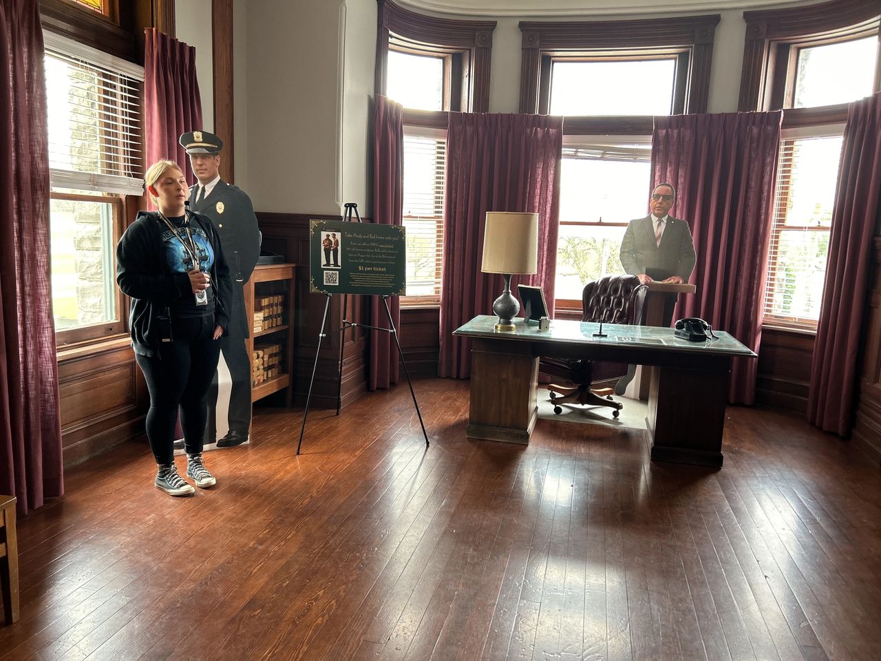 The Warden's Office at the Ohio State Reformatory featuring the dark wood desk, the 'His Judgment Cometh' embroidery, and the hidden wall safe used in The Shawshank Redemption.