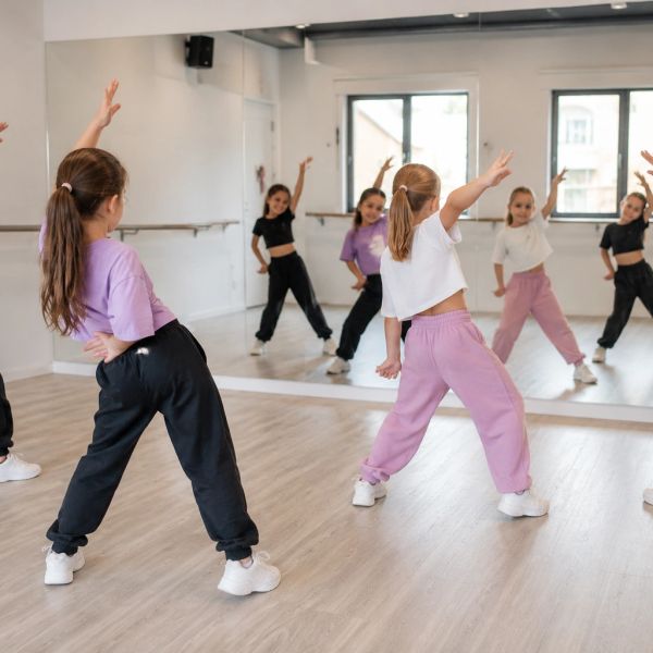 Niñas bailando frente a un espejo en una clase.