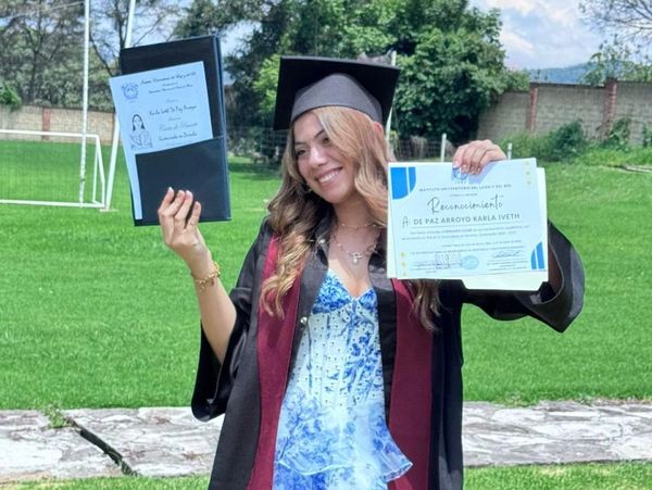 Joven graduada con diploma y birrete al aire libre.