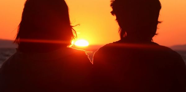 Silhouettes of a couple watching a romantic sunset on the book cover.