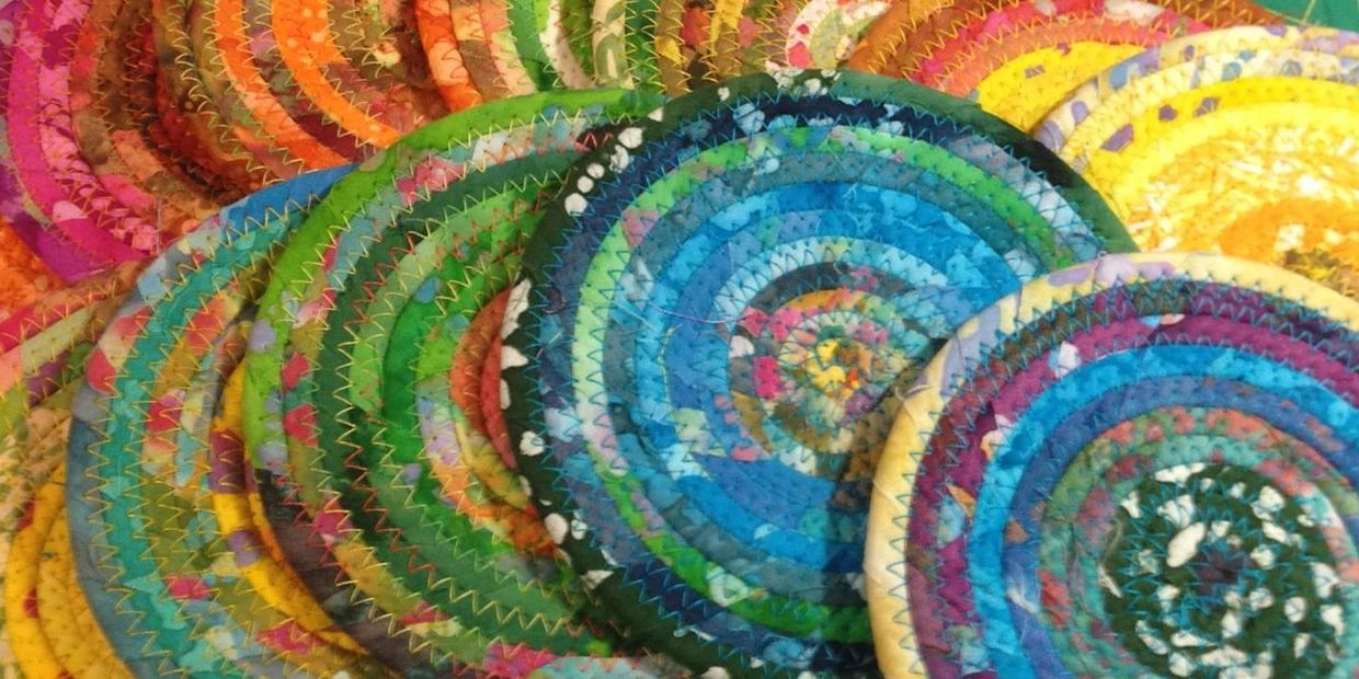 Several of my unique and colorful fabric covered coiled clothesline coasters.