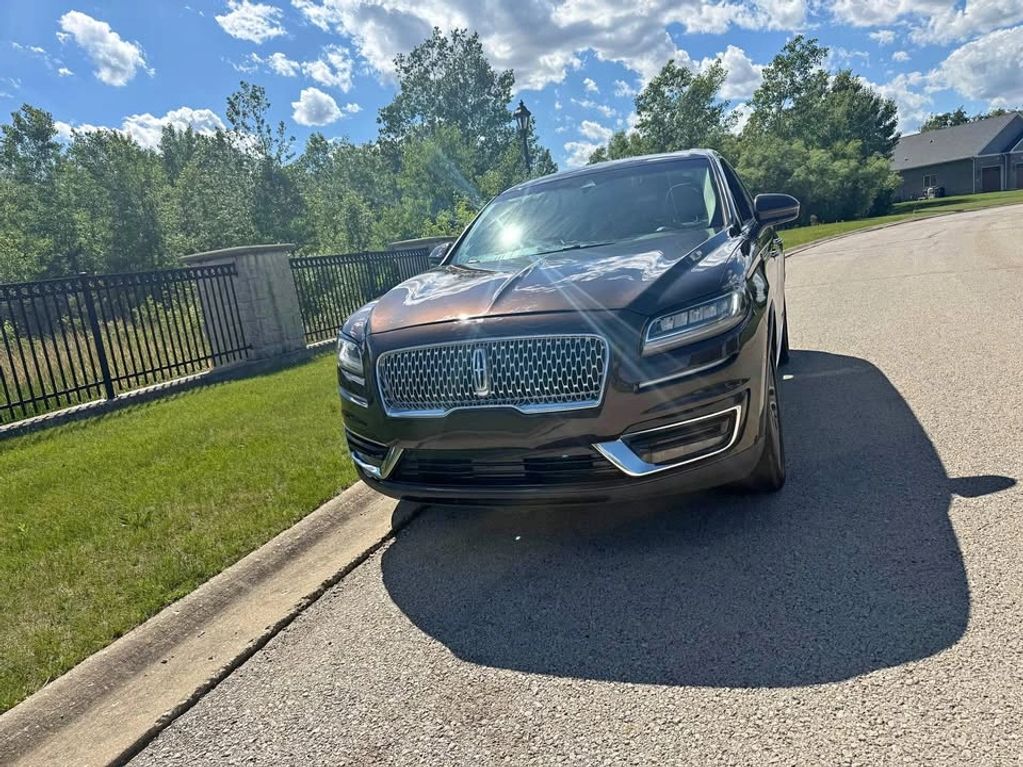 Black Lincoln SUV parked on the side of the street on a sunny day.