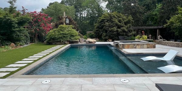 Modern backyard pool with clear water and lounge chairs.
