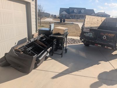 Pile of junk in a driveway removed by Herrera Hauling junk removal 