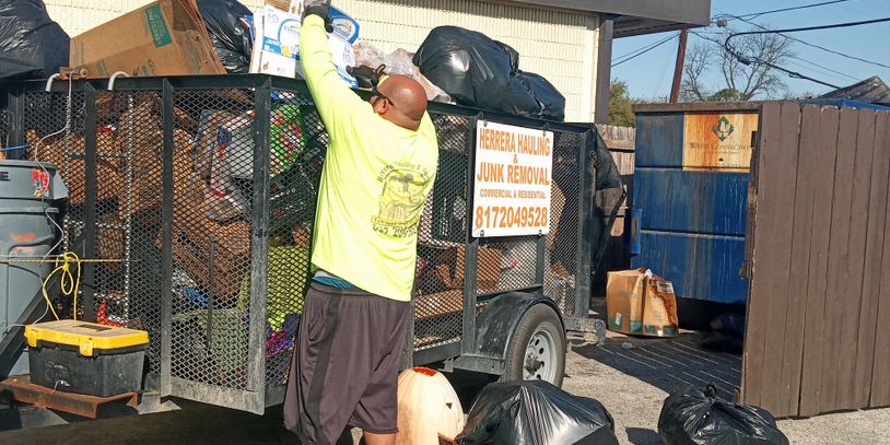 Man loading junk into a trailer from a commercial junk removal job in fort worth Texas 