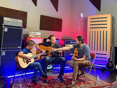 Guitar teacher and students in a music studio.