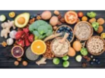 A colorful assortment of fresh fruits, vegetables, nuts, and grains on a dark surface.