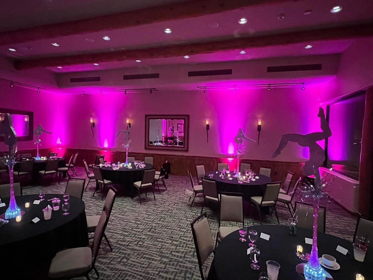 Venue accented by 4 uplighting units beaming bright pink splashes of color on light colored wall