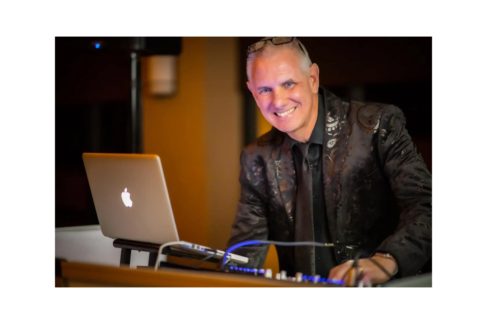 DJ Tony Fynan in a stylish suit plays a DJ set at a wedding, creating a lively atmosphere for all.