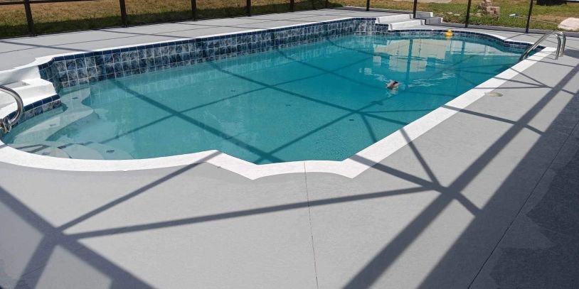 Clean swimming pool with tiled edge and clear blue water.