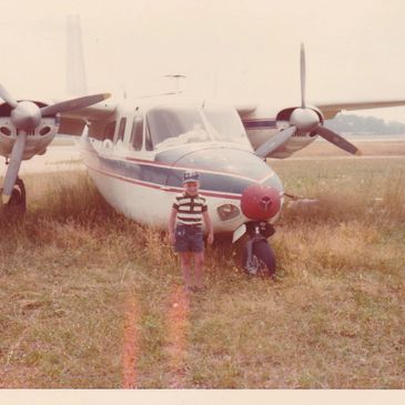 Image of young boy in front of twin engine plane.  Photo taken at Republic Airport in New York