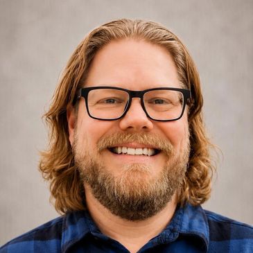 Smiling man with glasses and beard.