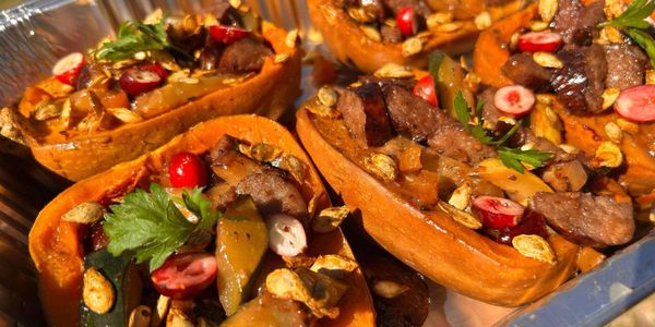 Roasted stuffed squash with sausage, veggies, and herbs.