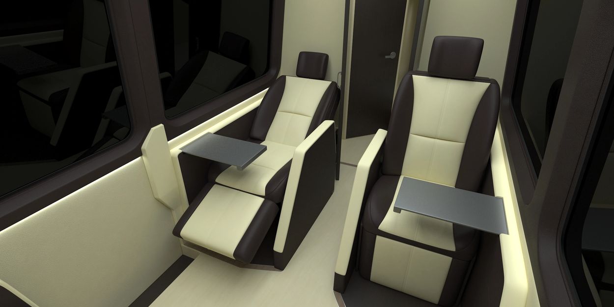 Luxurious reclining seats with foldable trays inside a vehicle or aircraft.
